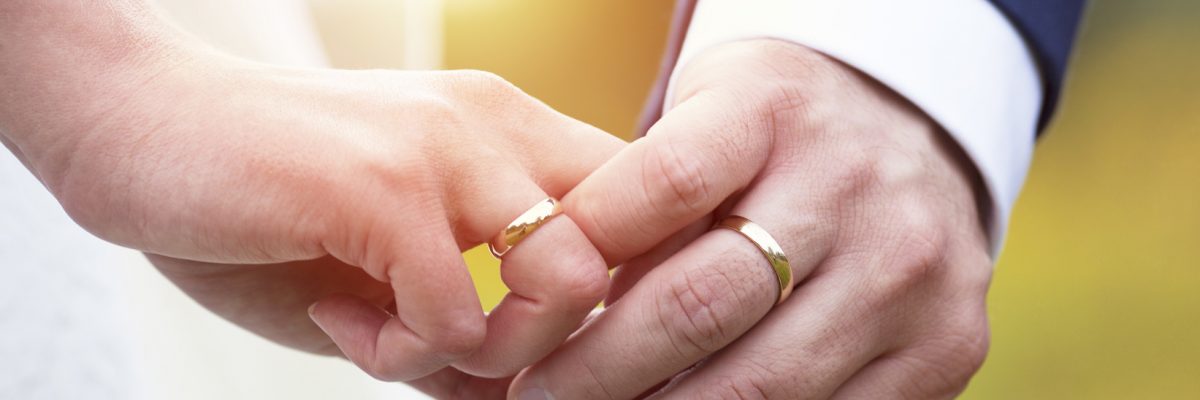 Dieses Bild zeigt die Hände mit den Ringen von einem frisch verheirateten Paar