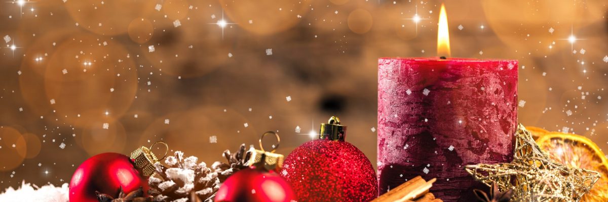 Dieses Bild zeigt eine Kerze mit Weihnachtsschmuck.