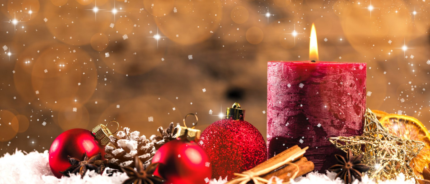 Dieses Bild zeigt eine Kerze mit Weihnachtsschmuck.