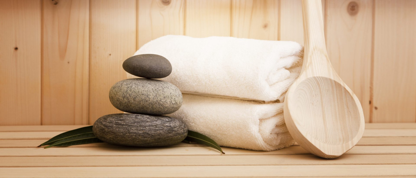 Handtücher und Steine in einer Sauna.