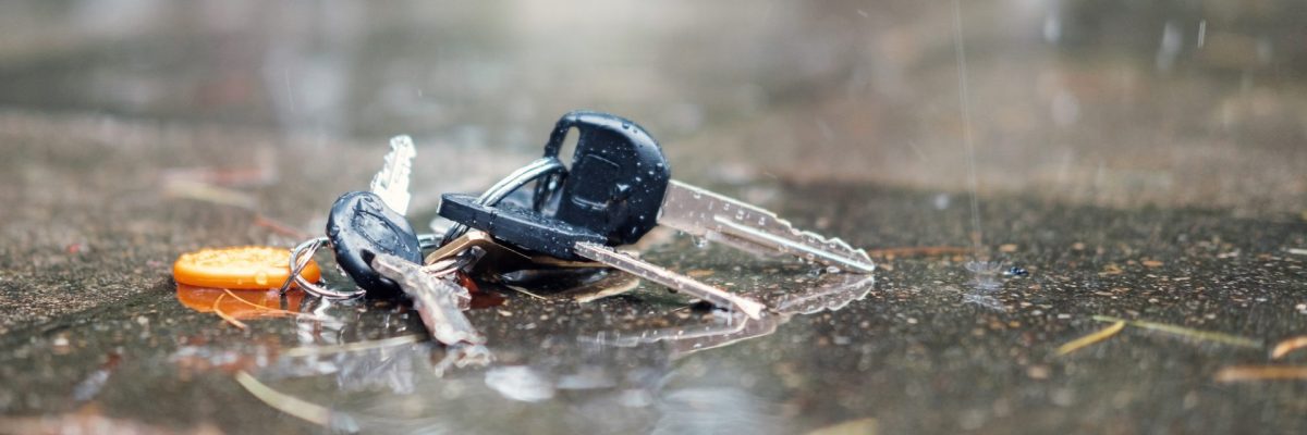 Dieses Bild zeigt einen verlorenen Schlüsselbund am Boden im Regen liegend.