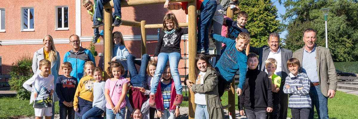 Dieses Bild zeigt die Schülerinnen und Schüler der Volksschule Munderfing bei der Übergabe des Klettersechsecks gemeinsam mit (v.l.n.r.) Amtsleiterin Rebekka Krieger, Andreas Permatinger-Kraus (AMAG Projektpate), Leopold Pöcksteiner (AMAG) und Bürgermeister Martin Voggenberger. (Foto: AMAG)