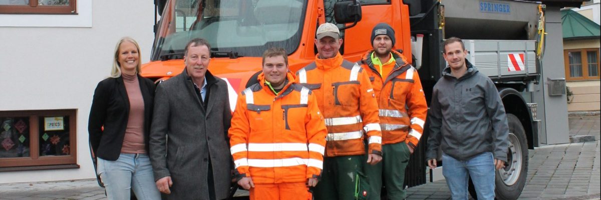 Dieses Bild zeigt die Mitarbeiter des Bauhofes, Bürgermeister Martin Voggenberger, Vizebürgermeister Johannes Probst und Amtsleiterin Rebekka Krieger mit dem neuen Unimog U 430.