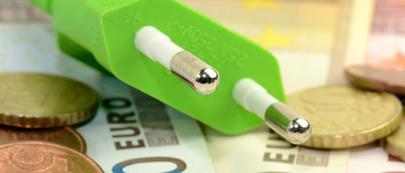 Dieses Bild zeigt ein Stromkabel das auf Geld liegt.