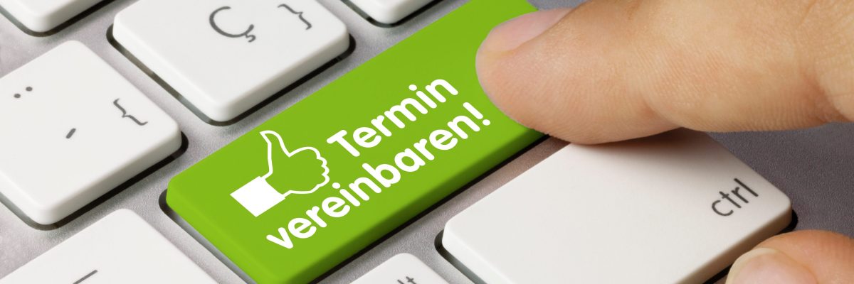 eine Computertastatur mit einer grünen Taste - beschriftet mit "Termin vereinbaren"