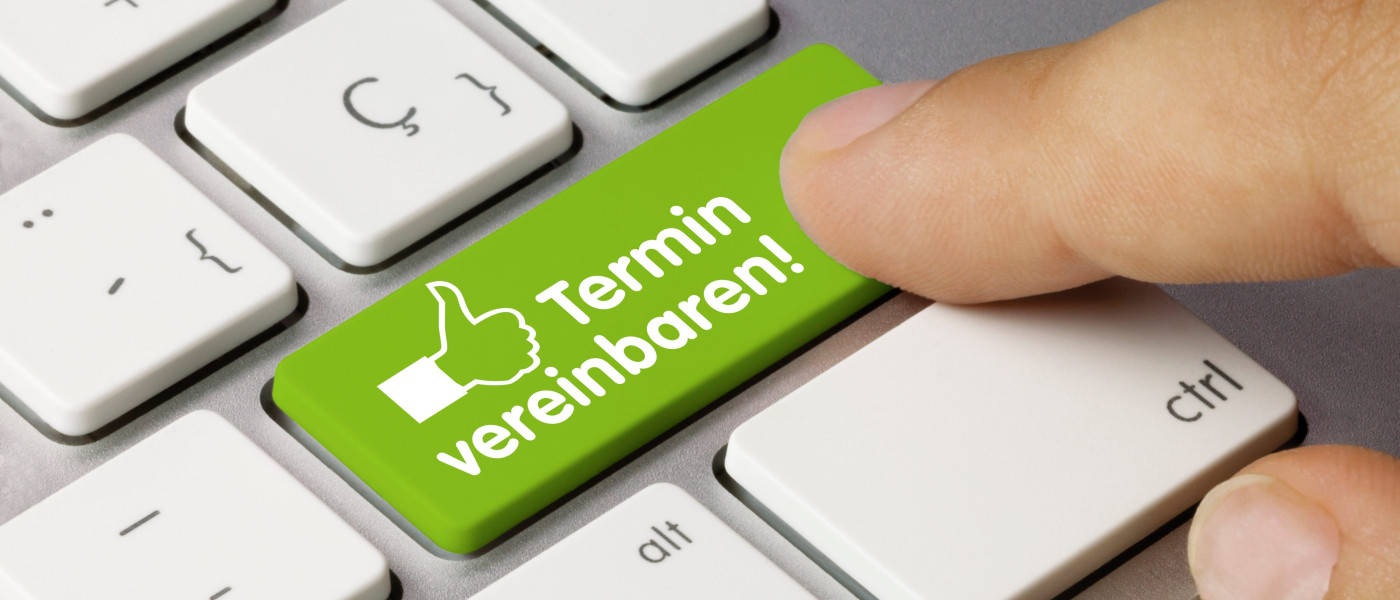 eine Computertastatur mit einer grünen Taste - beschriftet mit "Termin vereinbaren"