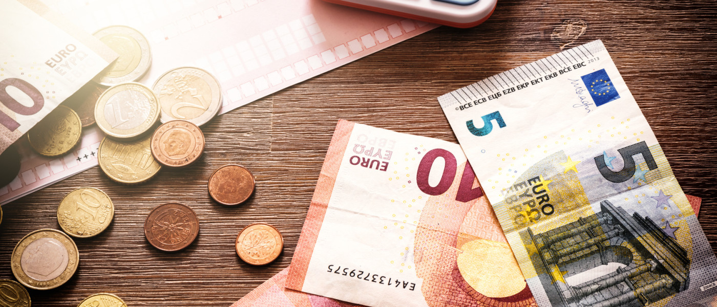 Dieses Bild zeigt einen Tisch mit Bargeld und einen Taschenrechner.