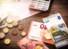 Dieses Bild zeigt einen Tisch mit Bargeld und einen Taschenrechner.