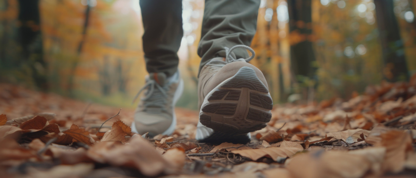 Dieses Bild zeigt die Beine eines Menschen beim wandern im Wald.